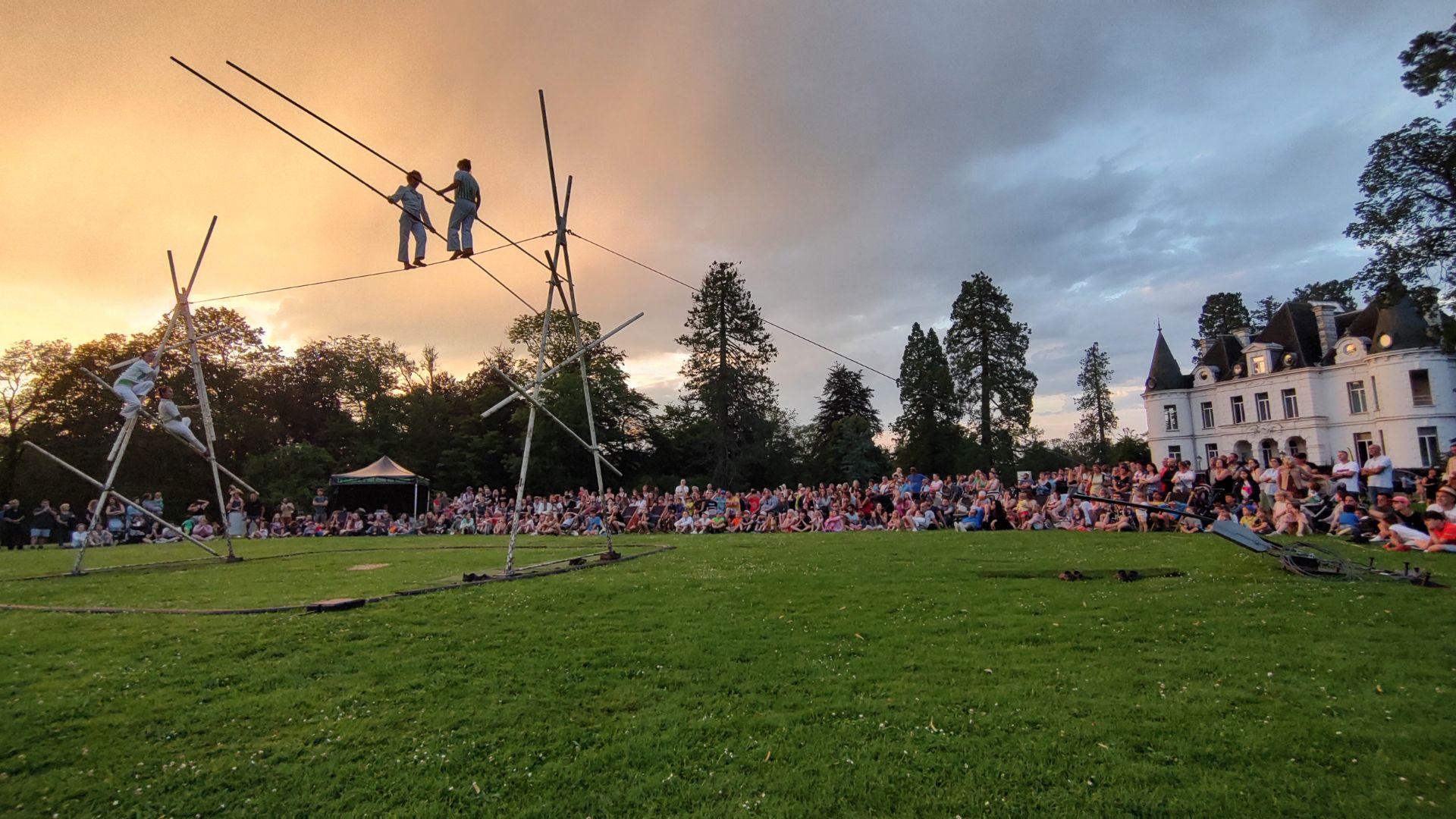 Le public qui regade un spectacle d'acrobates au coucher du soleil